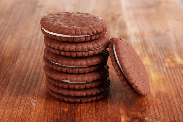 Čokoládové cookies s krémovou vrstvu na dřevěný stůl detail — Stock fotografie