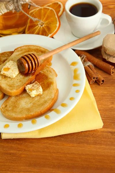 Tosty białego chleba z miodem i filiżankę kawy na drewnianym stole — Zdjęcie stockowe