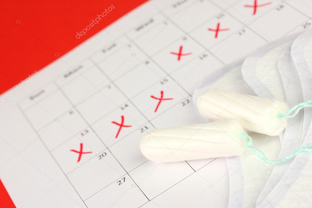 menstruation calendar with sanitary pads and tampons, close-up