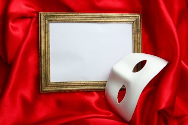 Beyaz maske ve kırmızı ipek kumaş üzerine boş çerçeve