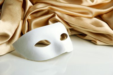 Beyaz maske ve altın ipek kumaş üzerine beyaz izole,
