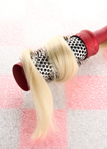 Kamm-Bürste mit Haaren auf rosa Fliese Wandhintergrund — Stockfoto
