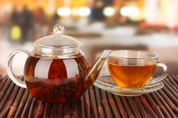 Exotic green tea with flowers in glass teapot on bright background — Stock Photo, Image