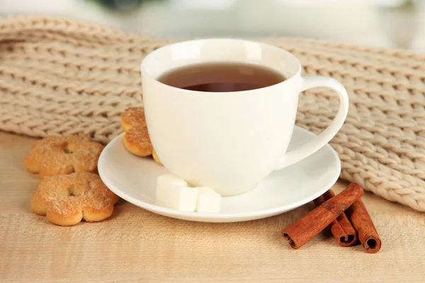 Tasse de thé avec écharpe sur la table dans la chambre — Photo