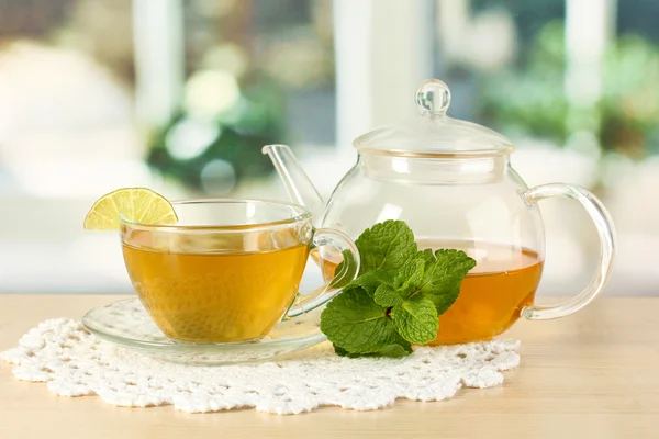 Xícara de chá com hortelã e limão na mesa no quarto — Fotografia de Stock
