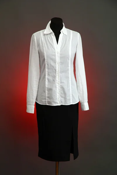 White blouse and black skirt with coat on mannequin on color background — Stock Photo, Image