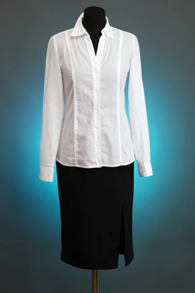 White blouse and black skirt with coat on mannequin on color background — Stock Photo, Image