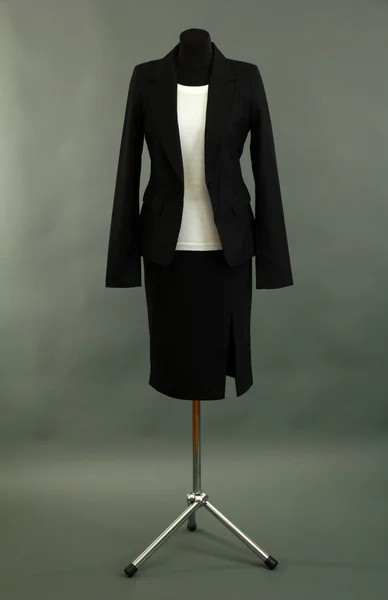 White blouse and black skirt with coat on mannequin on grey background — Stock Photo, Image