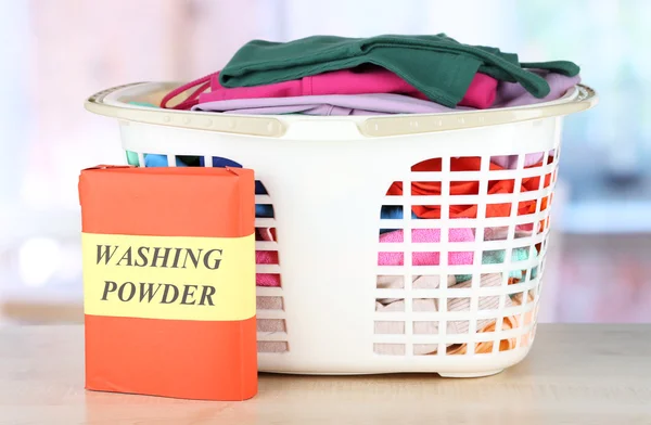 Clothes in plastic basket on table in room — Stock Photo, Image