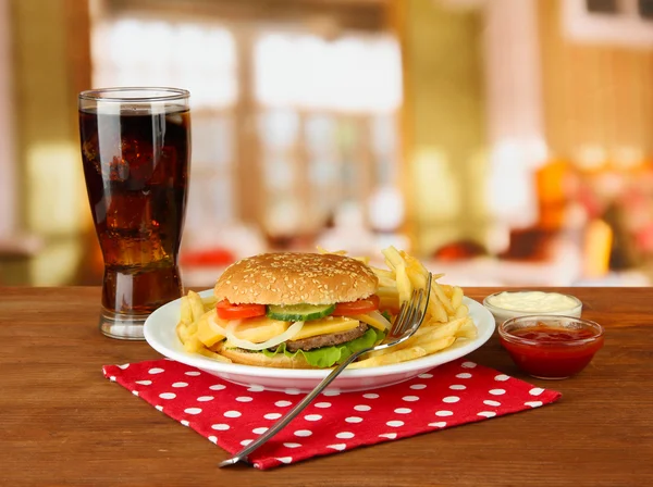 patates kızartması ve parlak zemin üzerine soğuk içecek ile lezzetli peynirli burger