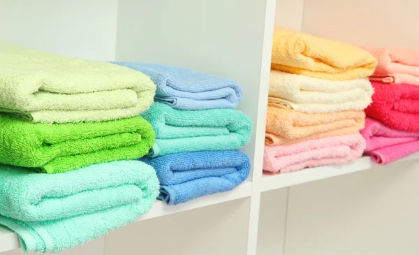 Colorful towels on shelves in bathroom — Stock Photo, Image