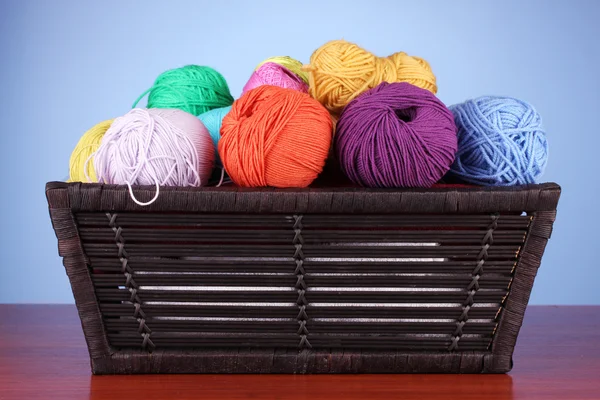 Colorful yarn balls in basket on color background — Stock Photo, Image