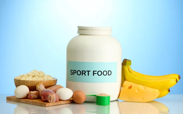 Jar of protein powder and food with protein, on blue background — Stock Photo, Image