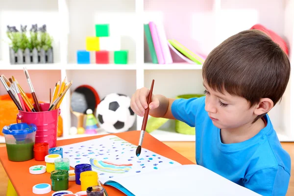 Bonito menino pintando em seu caderno — Fotografia de Stock