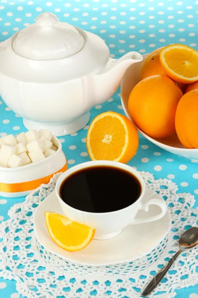 Beautiful white dinner service with oranges on blue tablecloth close-up — Stock Photo, Image