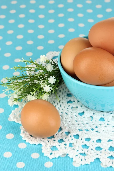 Eggs in bowl on blue tablecloth close-up — Stock Photo, Image