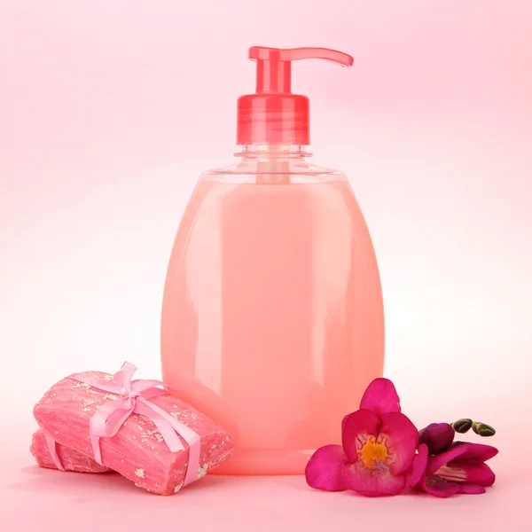 Sabonetes líquidos e feitos à mão sobre fundo rosa — Fotografia de Stock