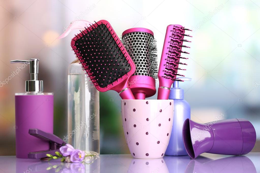 Hair brushes, hairdryer, straighteners and cosmetic bottles in beauty salon