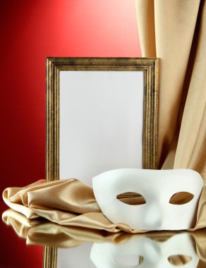 Beyaz maske, boş çerçeve ve kırmızı zemin üzerine altın ipek kumaş