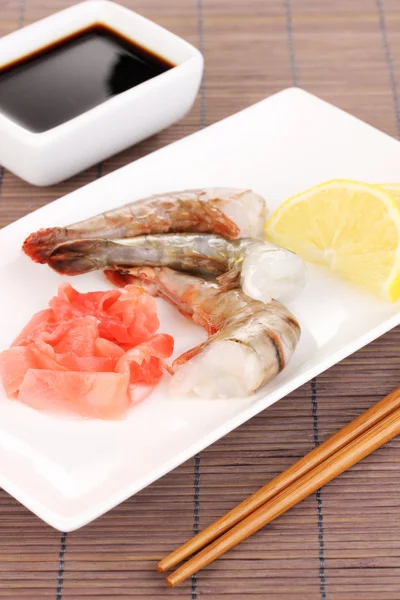 Espetos de camarão em prato com gengibre e limão — Fotografia de Stock