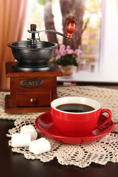 Kopp kaffe med halsduk och kaffe mal på bordet i rummet — Stockfoto