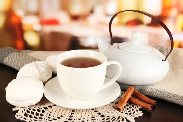 Cup of tea with scarf on table in room — Stock Photo, Image