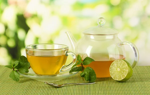 Cup of tea with mint and lime on table on bright background — Stock Photo, Image