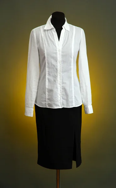 Blusa blanca y falda negra con abrigo sobre maniquí sobre fondo de color — Foto de Stock