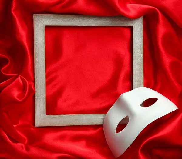 Beyaz maske ve kırmızı ipek kumaş üzerine boş çerçeve
