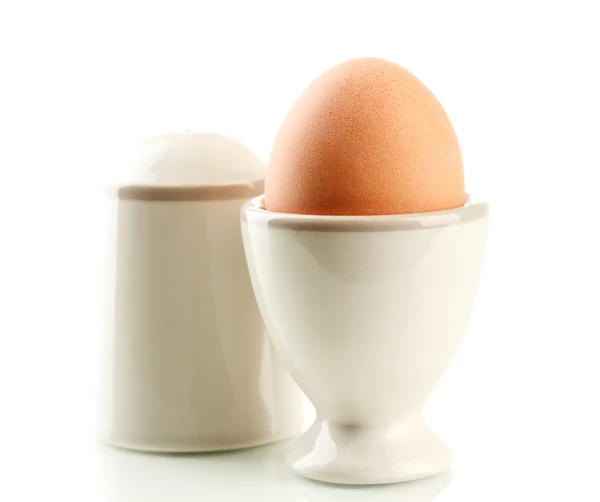 Целое вареное яйцо в яичной чашке и соли, изолированные на белом — стоковое фото