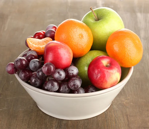 Bowl with fruits, on wooden table — Stock Photo, Image
