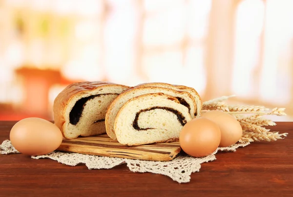 Loaf with poppy seed on cutting board, on bright background — Stock Photo, Image