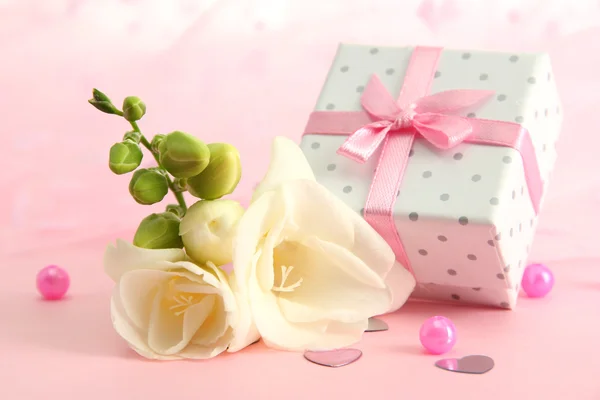 Schöne romantische Geschenkschachtel und Blume auf rosa Hintergrund — Stockfoto