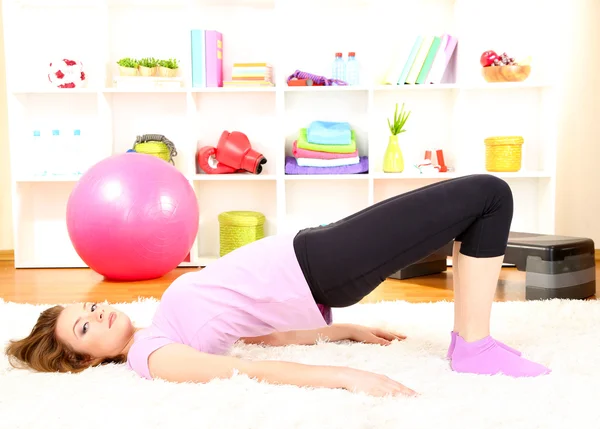 Giovane donna che fa esercizi di fitness a casa — Foto Stock