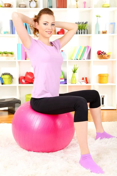 genç bir kadın fitness gym ball evde ile yapıyor