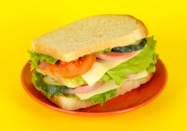 노란 배경에 접시에 샌드위치 — 스톡 사진