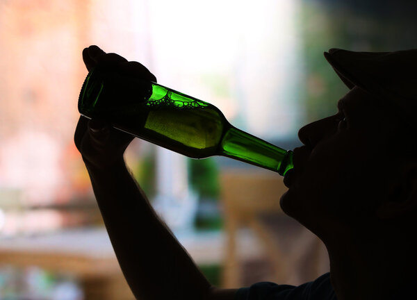 Silhouette of man drinking alcohol, close up