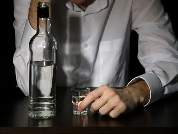 Hombre con botella de alcohol, sobre fondo negro —  Fotos de Stock