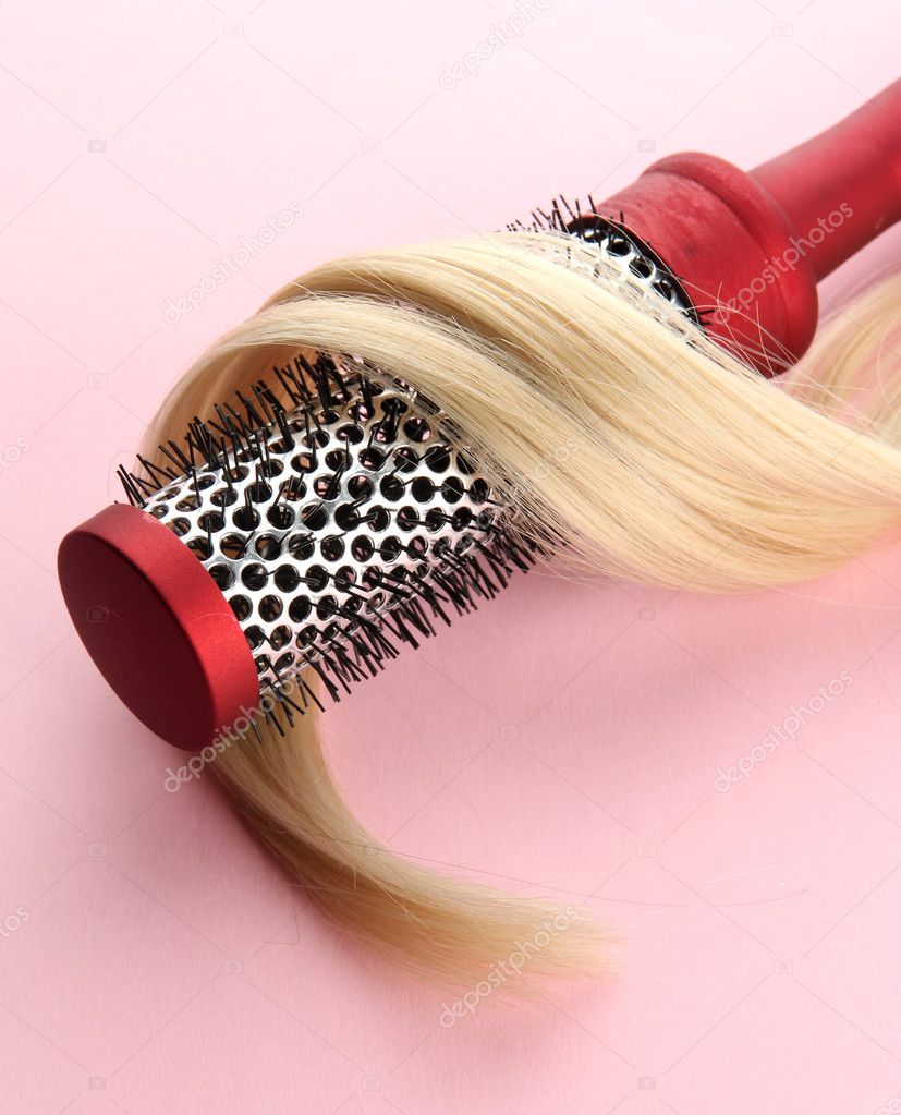 comb brush with hair, on pink background