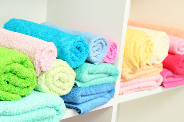 colorful towels on shelves in bathroom