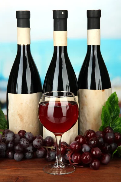 Composition of wine bottles, glass and grape, on bright background — Stock Photo, Image