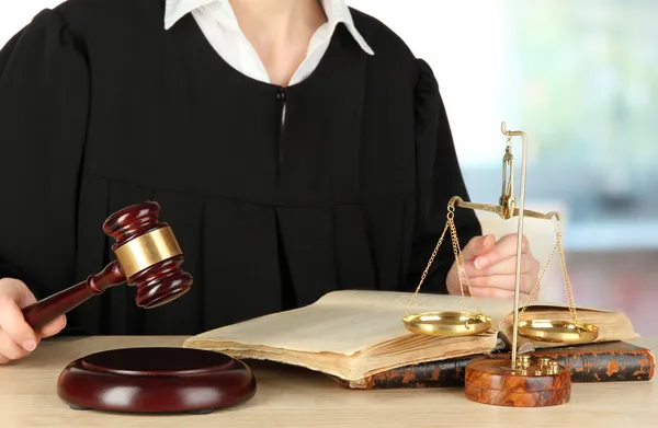 Juiz sentado à mesa durante as audiências judiciais sobre o fundo da sala — Fotografia de Stock