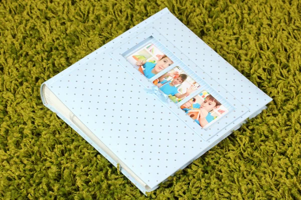 Photo album on green carpet — Stock Photo, Image