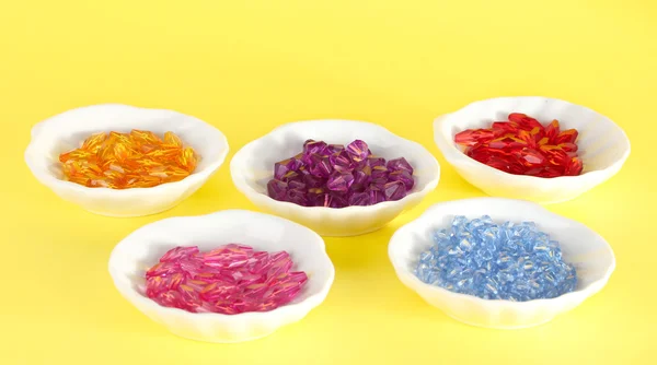 Beads in plates on yellow background — Stock Photo, Image