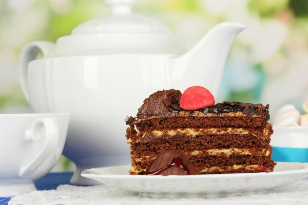 Teekanne, Tasse Tee und leckerer Kuchen auf natürlichem Hintergrund — Stockfoto