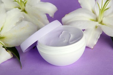 kozmetik krem ve mor zemin üzerine güzel zambak