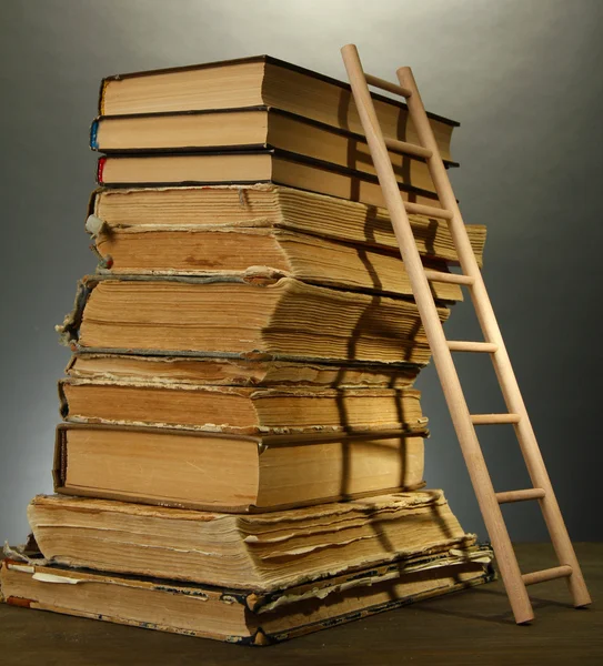 eski kitaplar ve Ahşap merdiven, gri arka plan üzerine