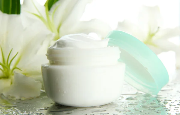 Cosmetic cream and beautiful lily, close up — Stock Photo, Image