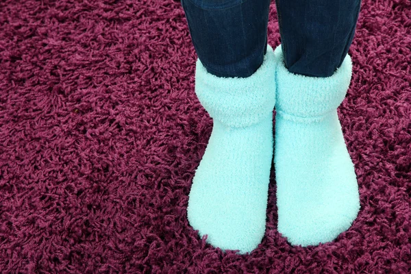 女性双腿在多彩袜子的颜色地毯背景 — 图库照片