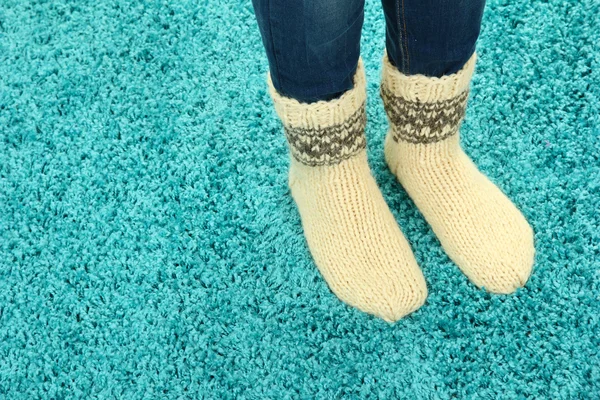 Gambe femminili in calzini colorati su sfondo tappeto di colore — Foto Stock